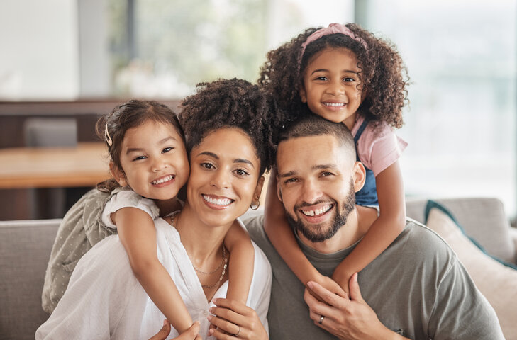 Familia sonriendo unida en casa